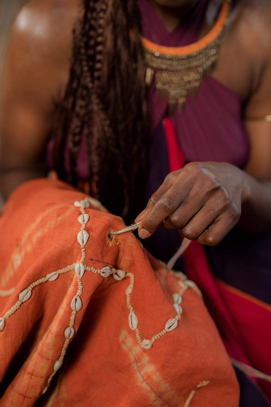 a person sewing in shells on a textile