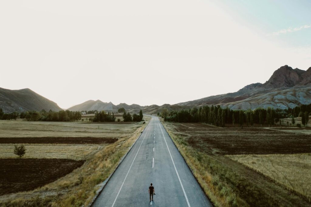 a person standing alone on country road