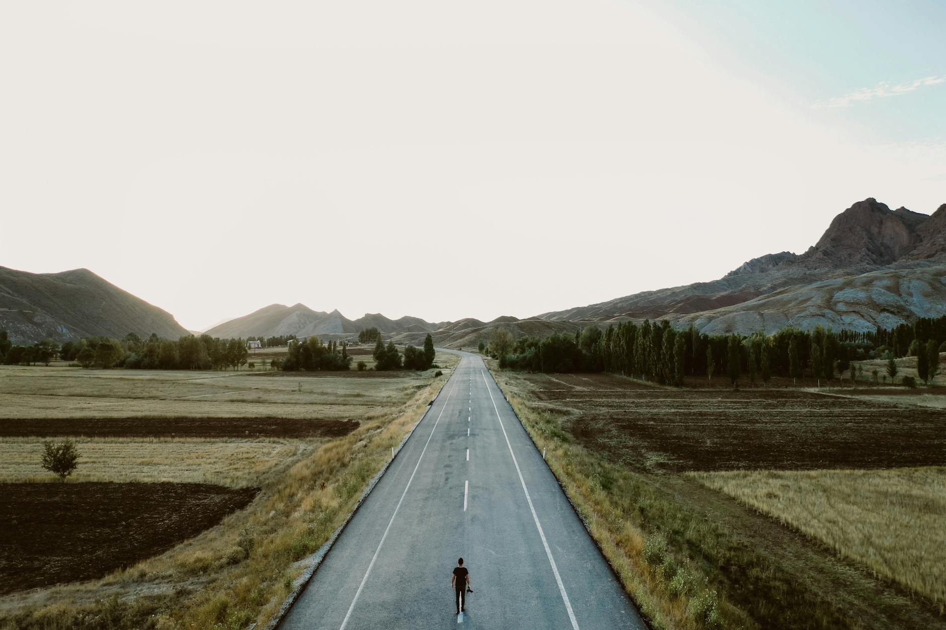 a person standing alone on country road